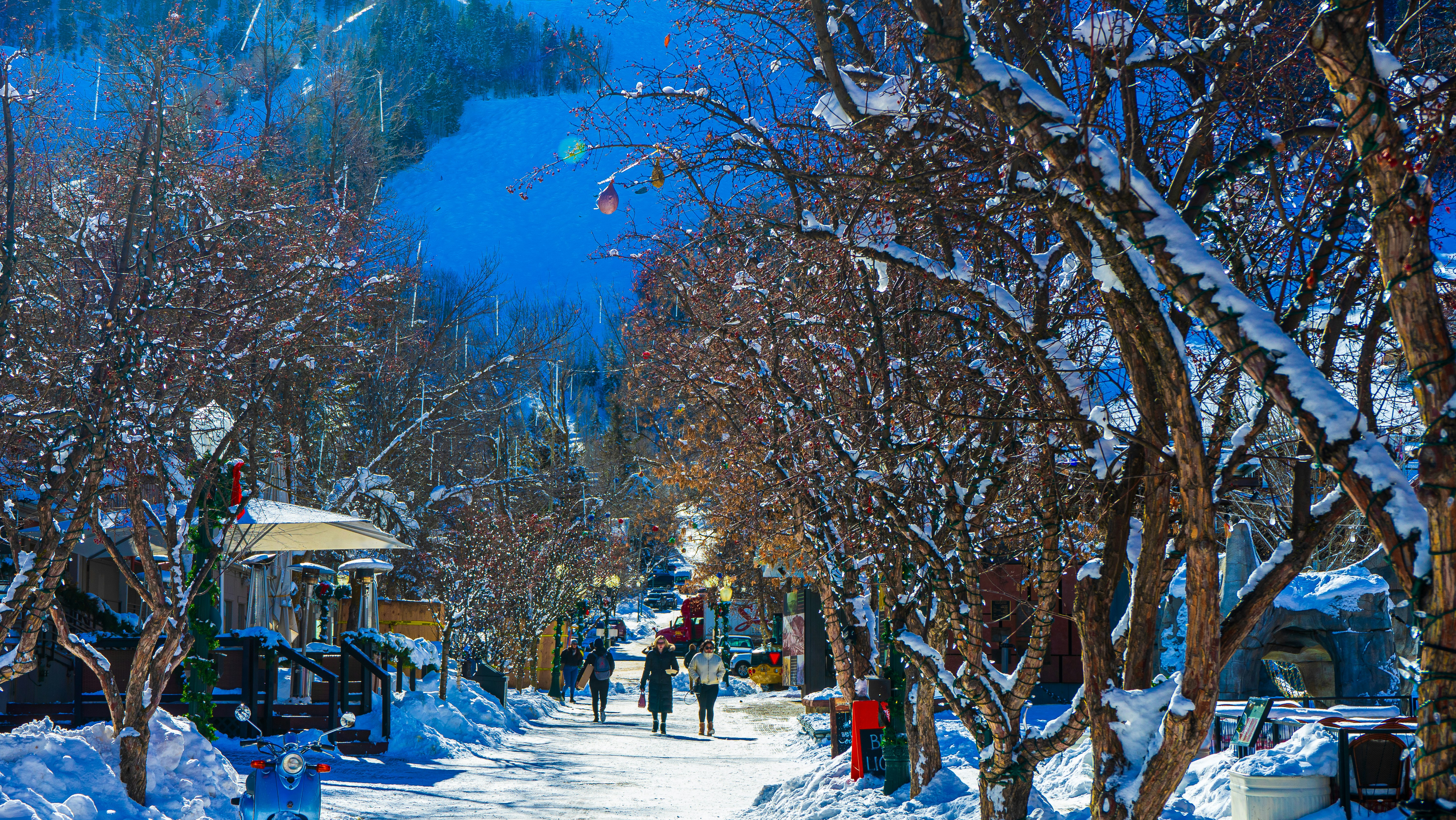 a snowy street with people walking down it