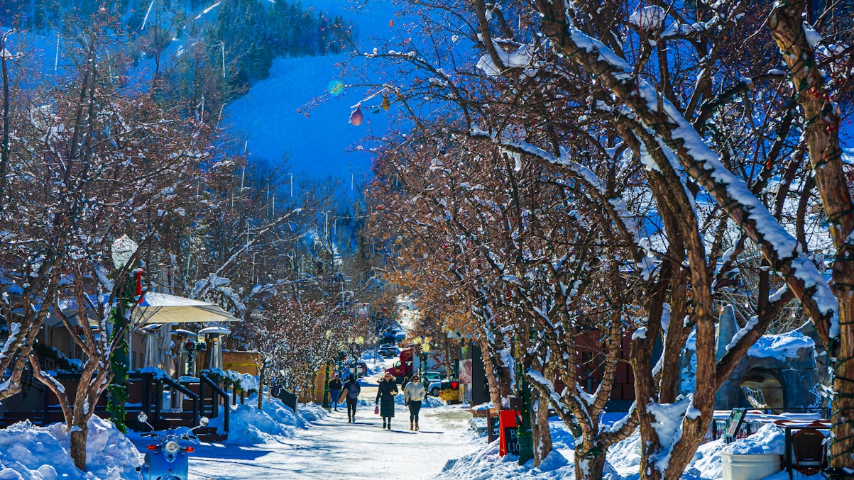 a snowy street with people walking down it