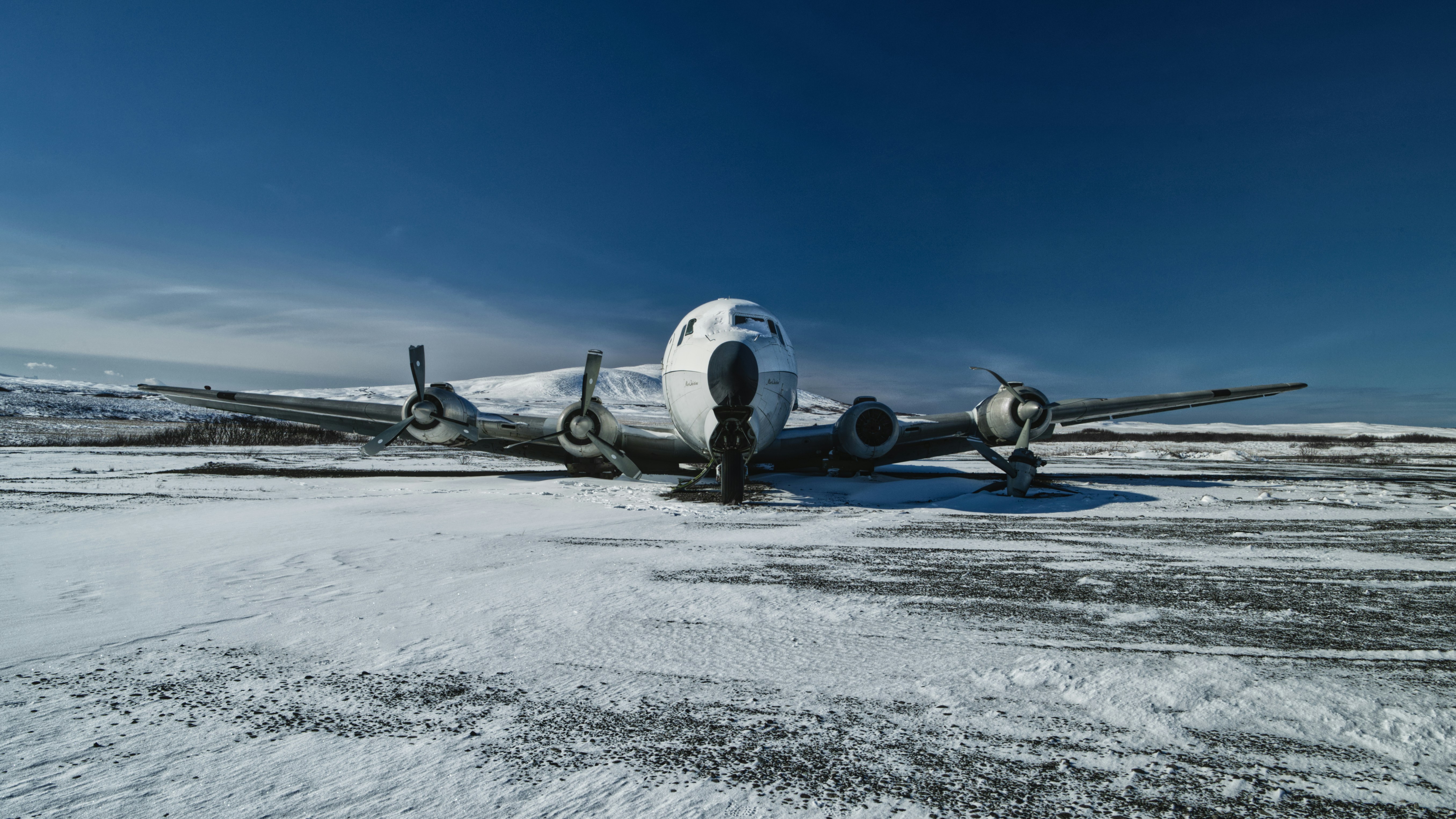 an airplane is parked on a snowy runway, 