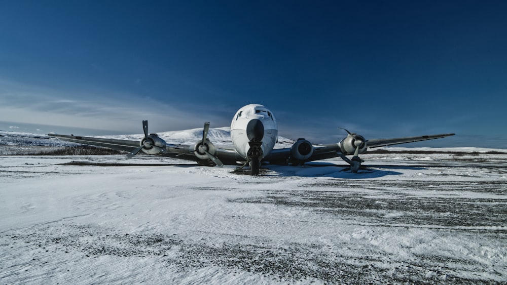 an airplane is parked on a snowy runway