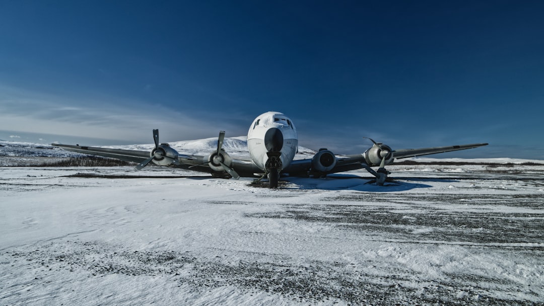 an airplane is parked on a snowy runway,
