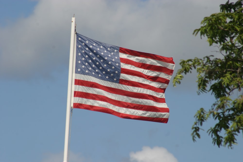 a large american flag flying in the wind