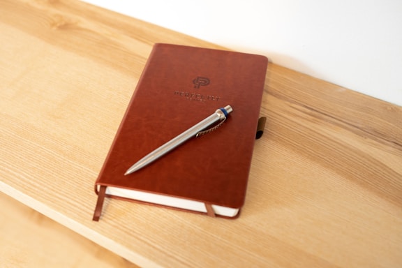 a notebook with a pen on top of it