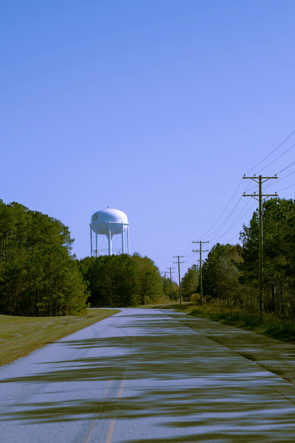 a road with a water tower in the distance