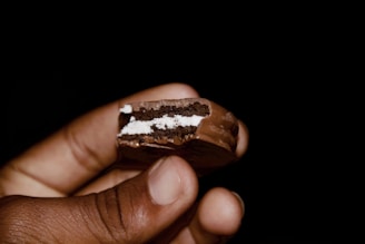 a person holding a piece of cake in their hand