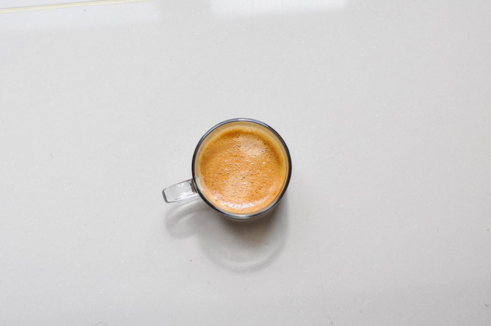 a cup of coffee sitting on top of a table