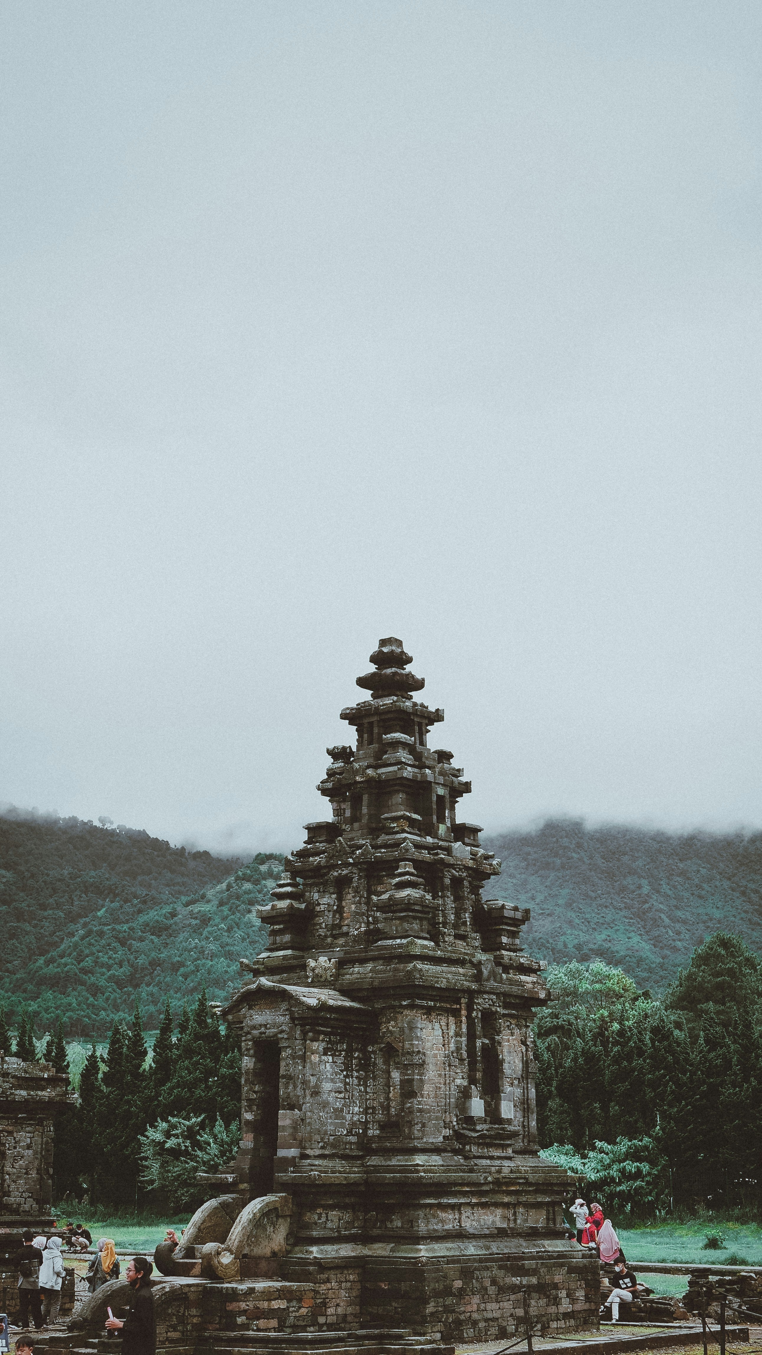 a group of people standing around a stone structure