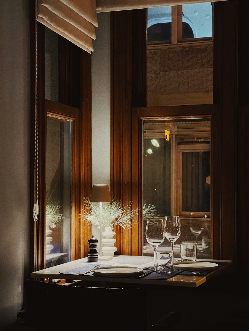 a dining room table with place settings and wine glasses