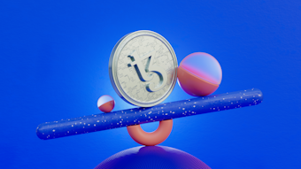 A Tezos cryptocurrency coin is balanced on a blue speckled cylinder. The setup includes a larger sphere with a pink and purple gradient and a smaller pink sphere. The background is vibrant blue.