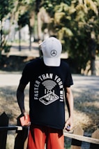 a man wearing a hat and holding a skateboard