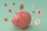 A pink piggy bank surrounded by floating digital currency coins with various cryptocurrency symbols. The background is a soft green color, and the coins feature symbols for Bitcoin, Ethereum, and Binance Coin, among others.