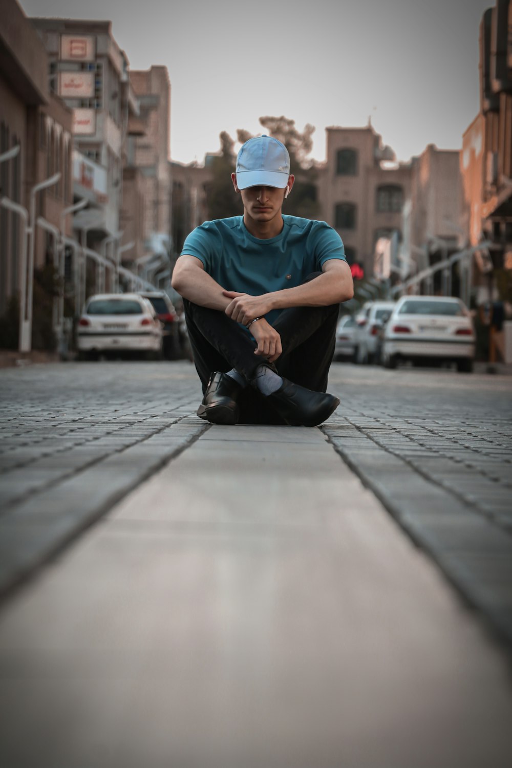 a man sitting on the ground in front of a street