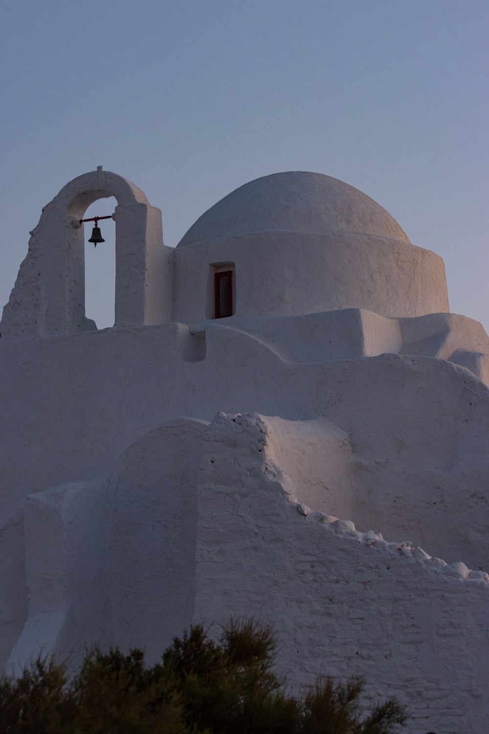 a white building with a bell on top of it