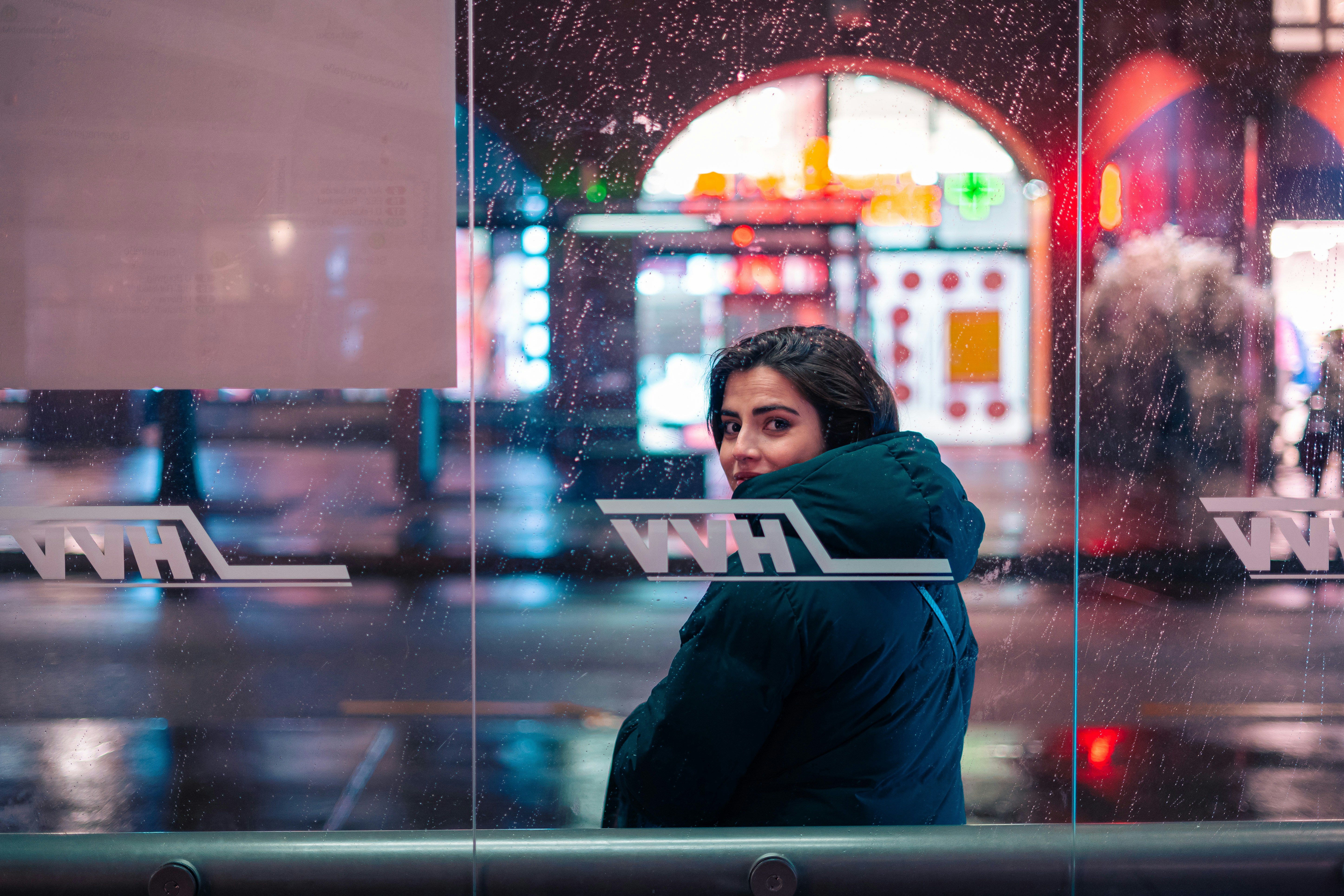 a woman standing in front of a glass wall