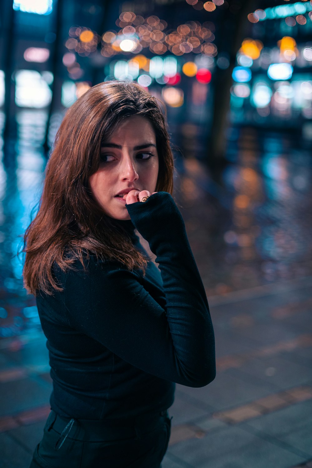 a woman standing on a sidewalk in the rain