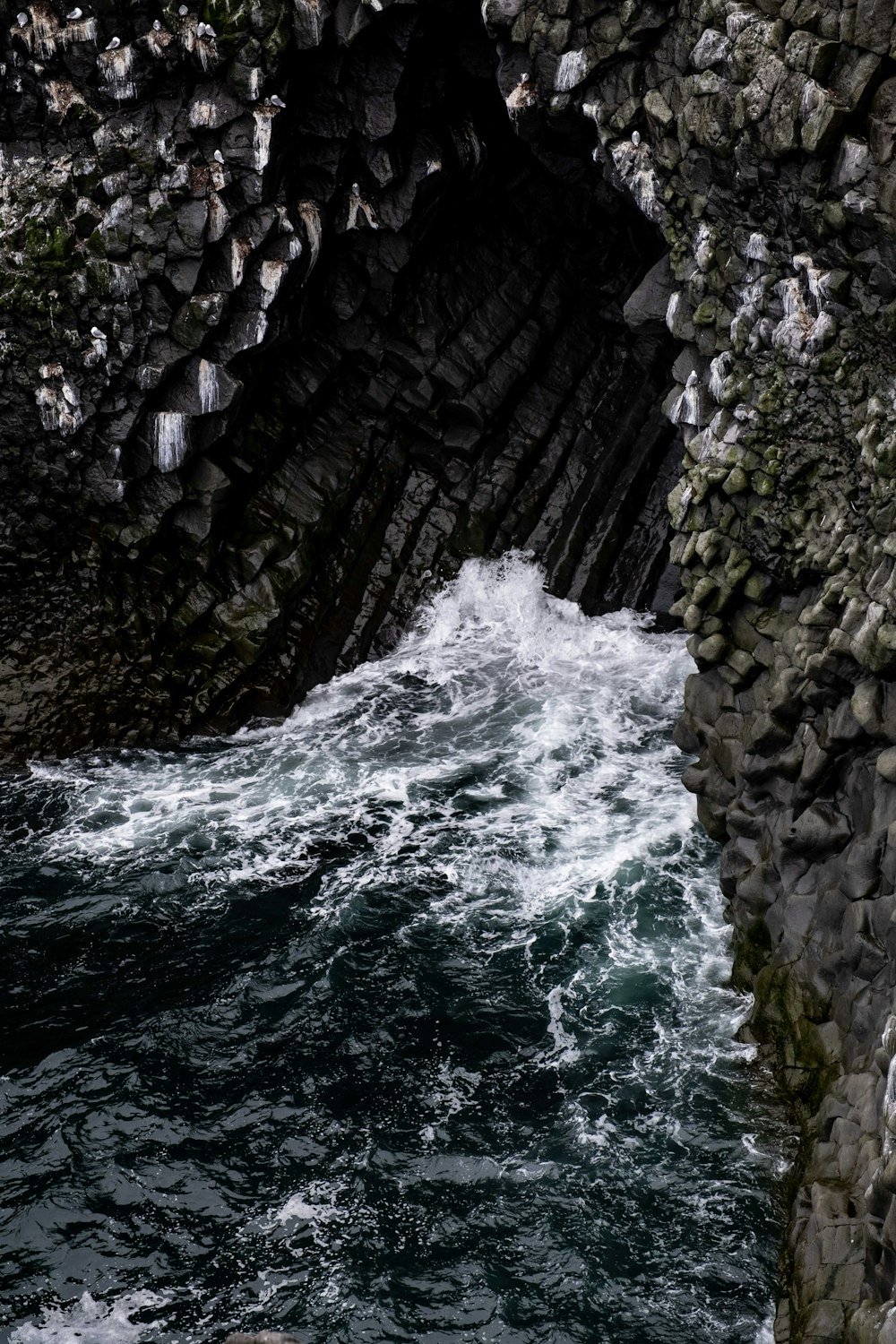 a large body of water next to a rocky cliff