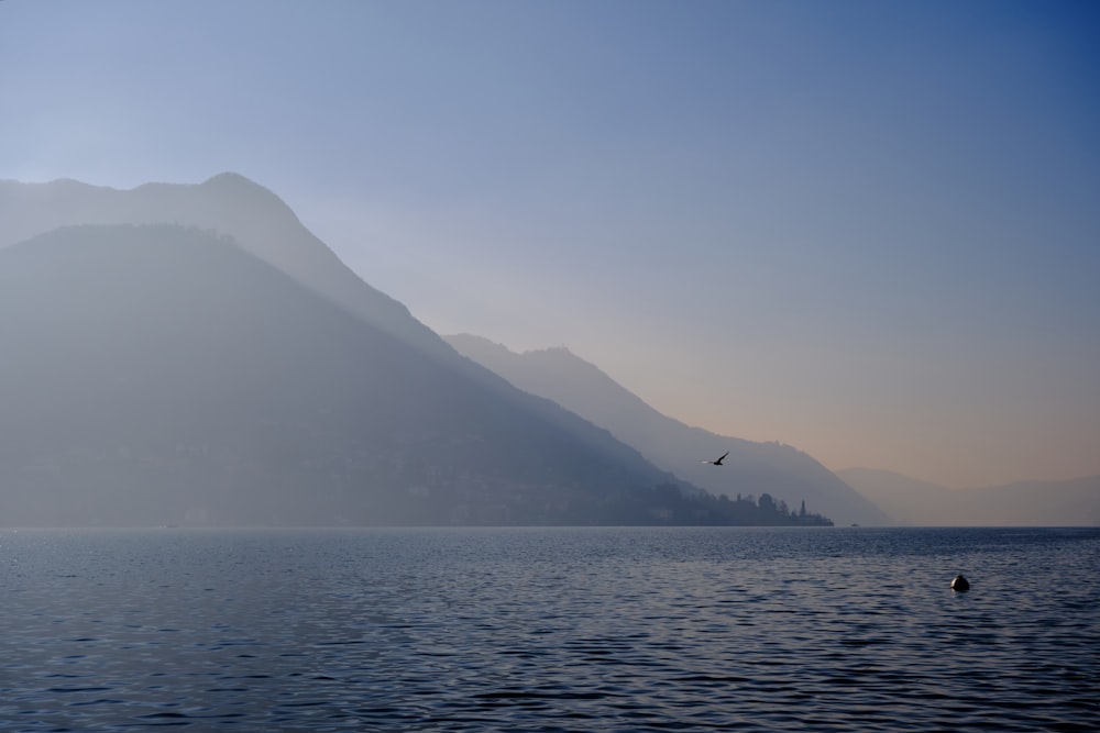 a large body of water with mountains in the background