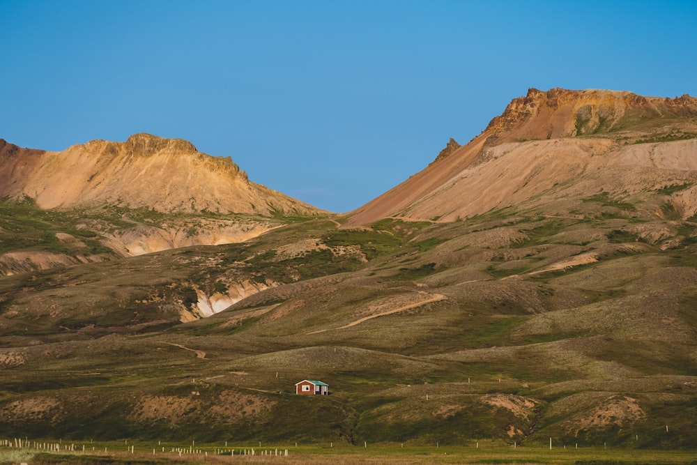 a mountain range with a house in the foreground