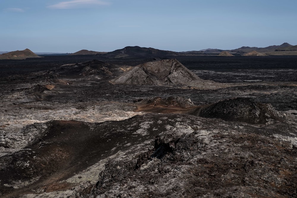 a barren landscape with mountains in the distance