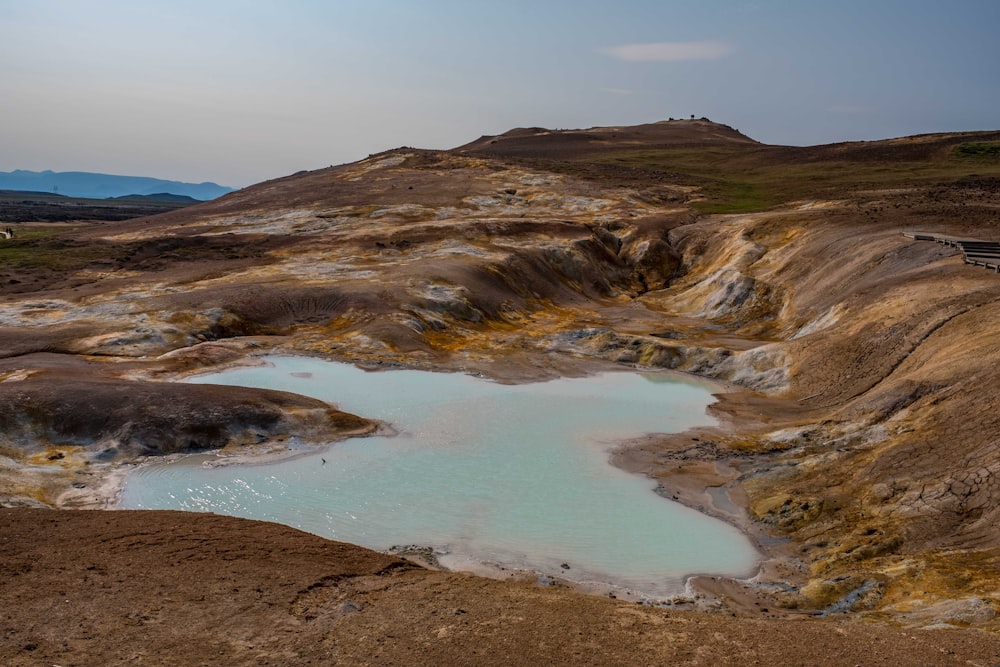 a small pool of water in a barren area