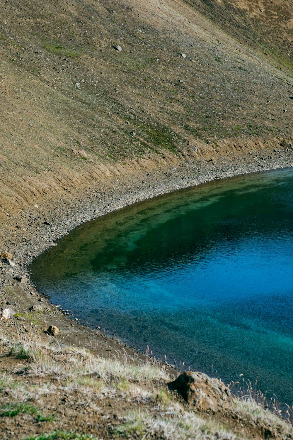 a body of water sitting on the side of a hill