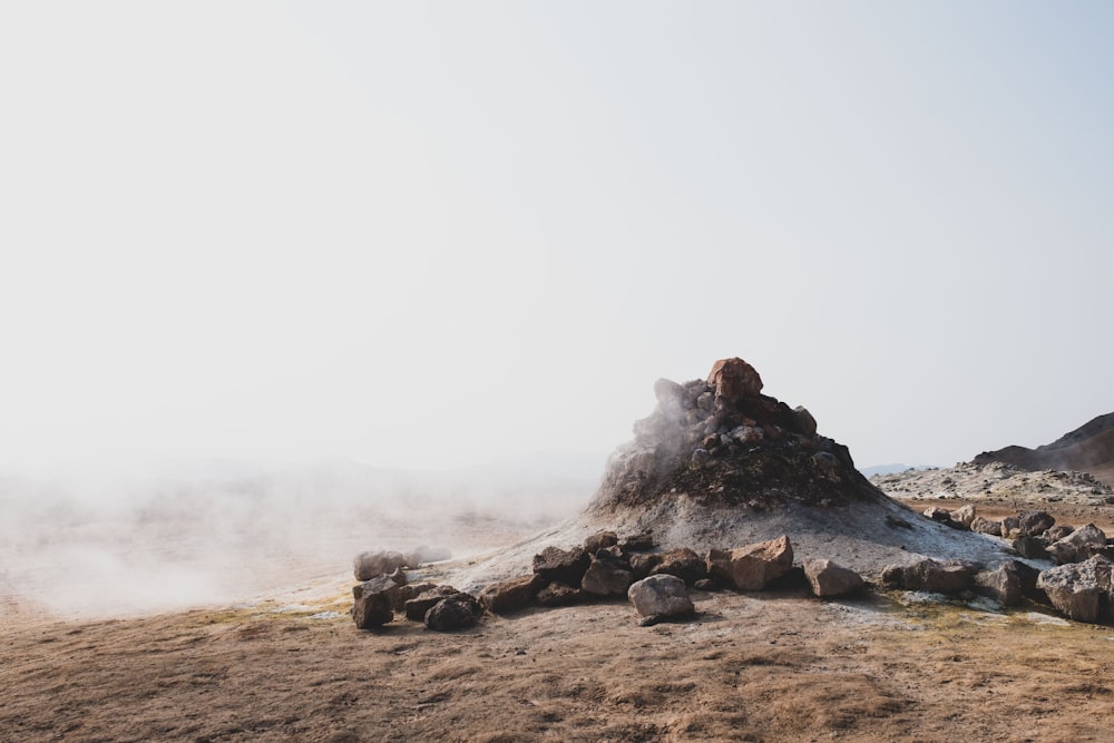 a pile of rocks sitting on top of a dry grass field