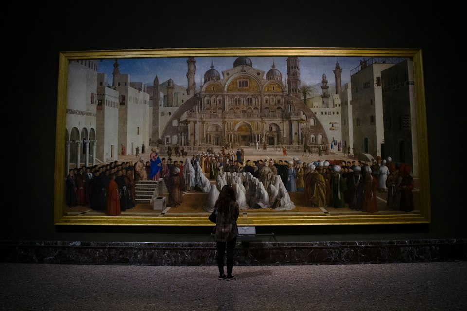 A visitor viewing a painting inside the Pinacoteca di Brera