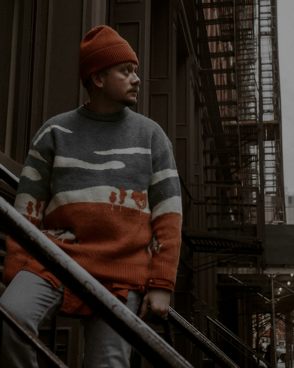 a man in a striped sweater is walking down a set of stairs