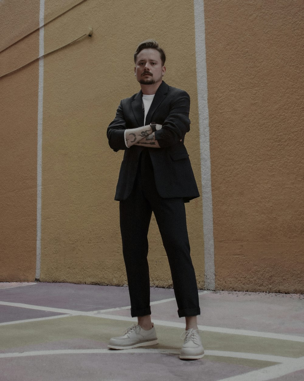 a man in a suit standing in a parking lot