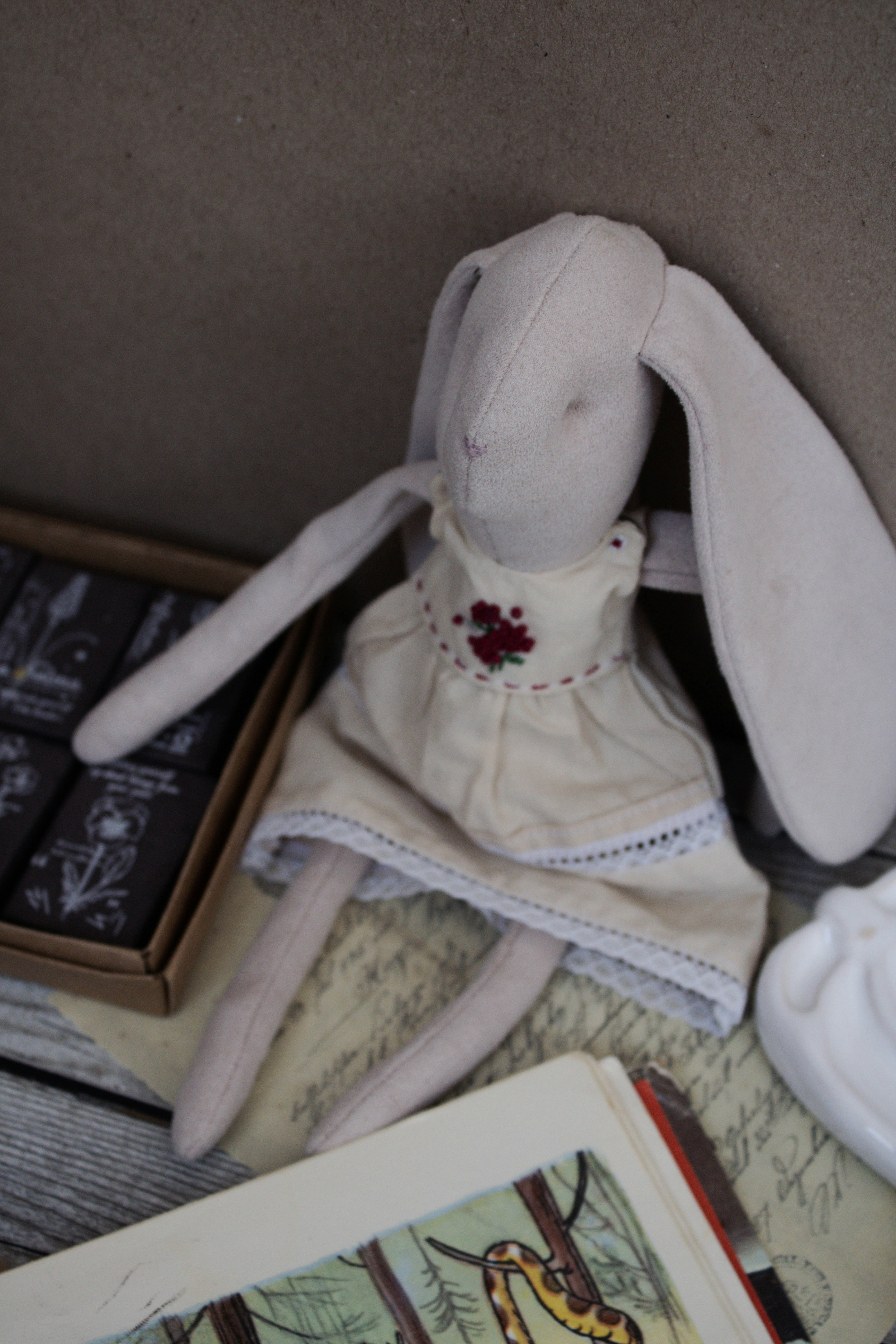 A stuffed rabbit sitting on top of a table next to a book photo – Free ...