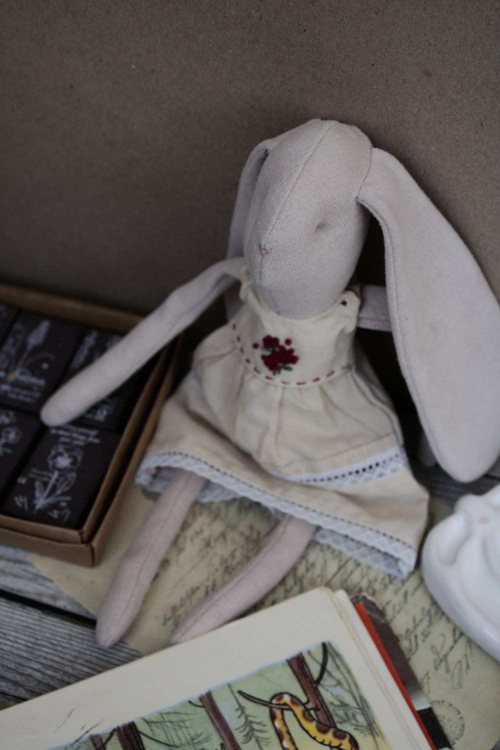 a stuffed rabbit sitting on top of a table next to a book