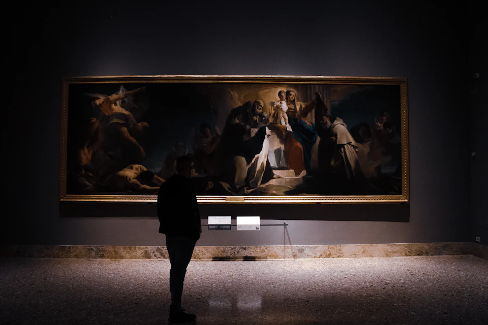 A person standing in front of a large painting