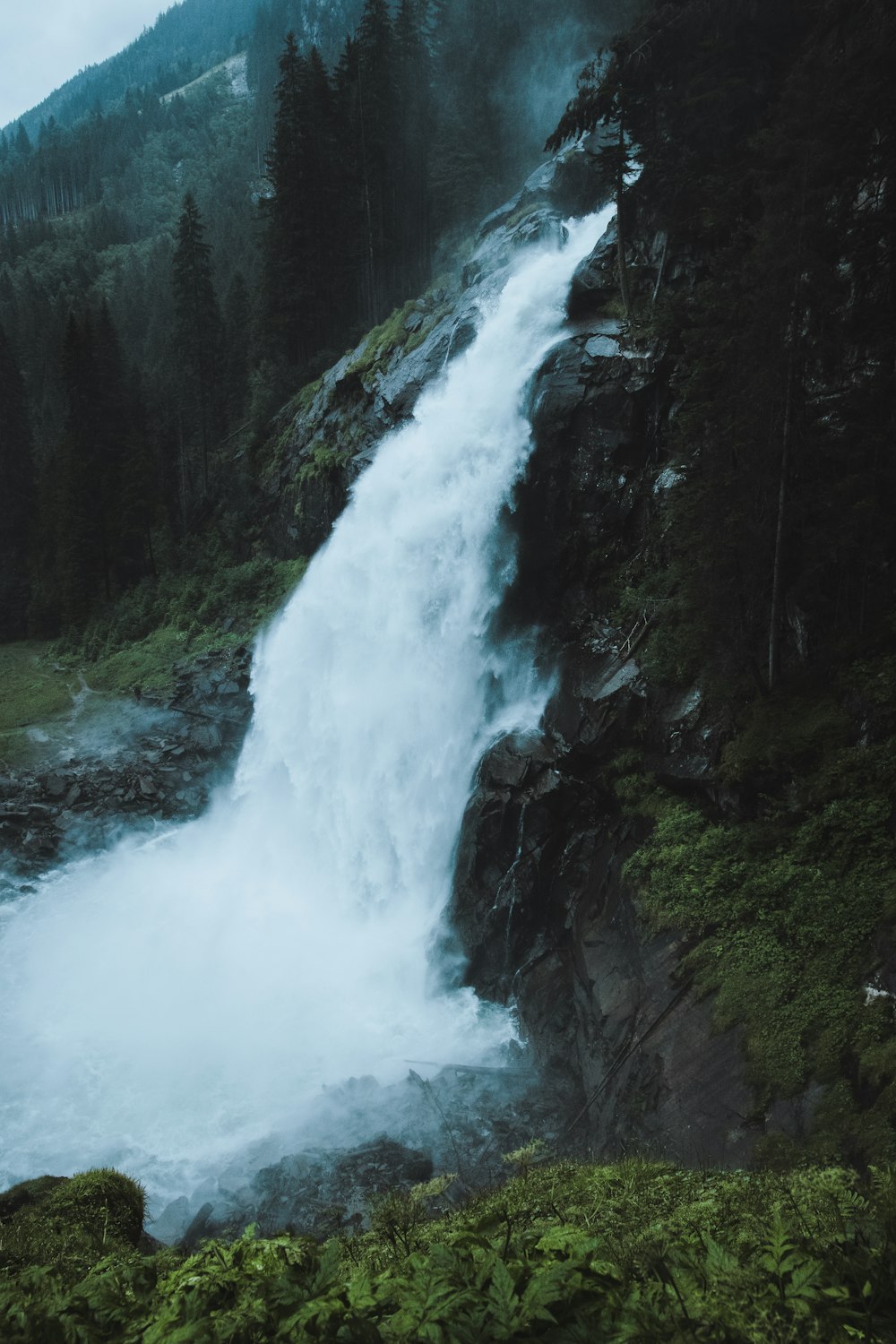 a large waterfall in the middle of a forest