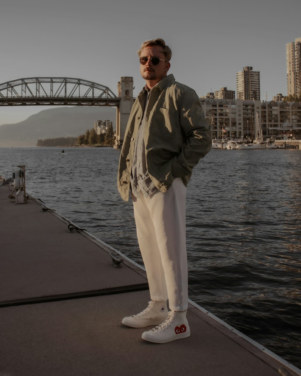 a man standing on a dock next to a body of water