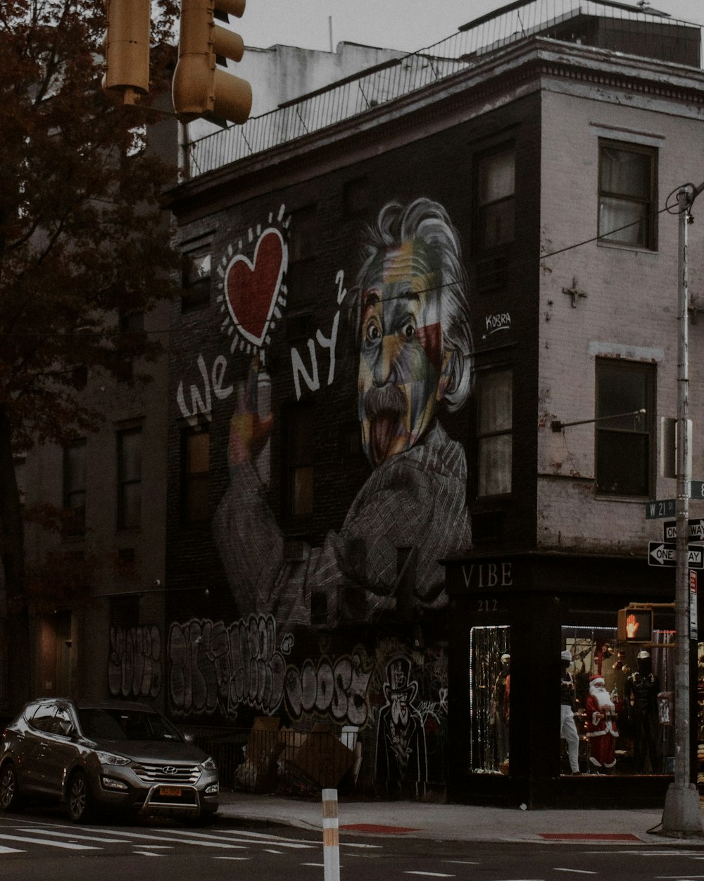 a street corner with a large mural of a man holding a heart