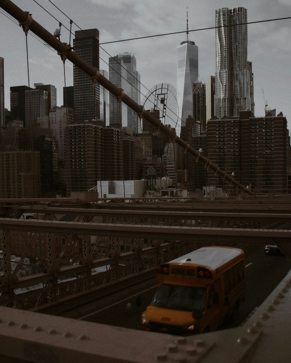 a yellow bus driving over a bridge in a city