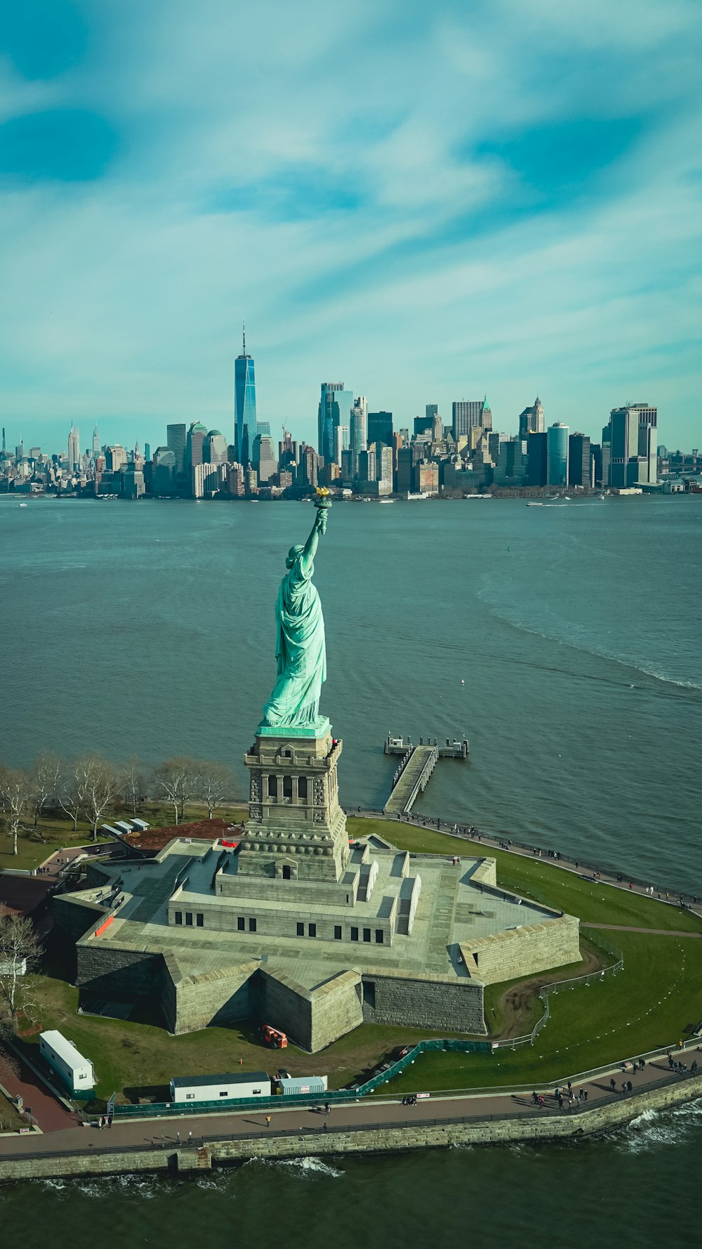 the statue of liberty stands in front of the city skyline