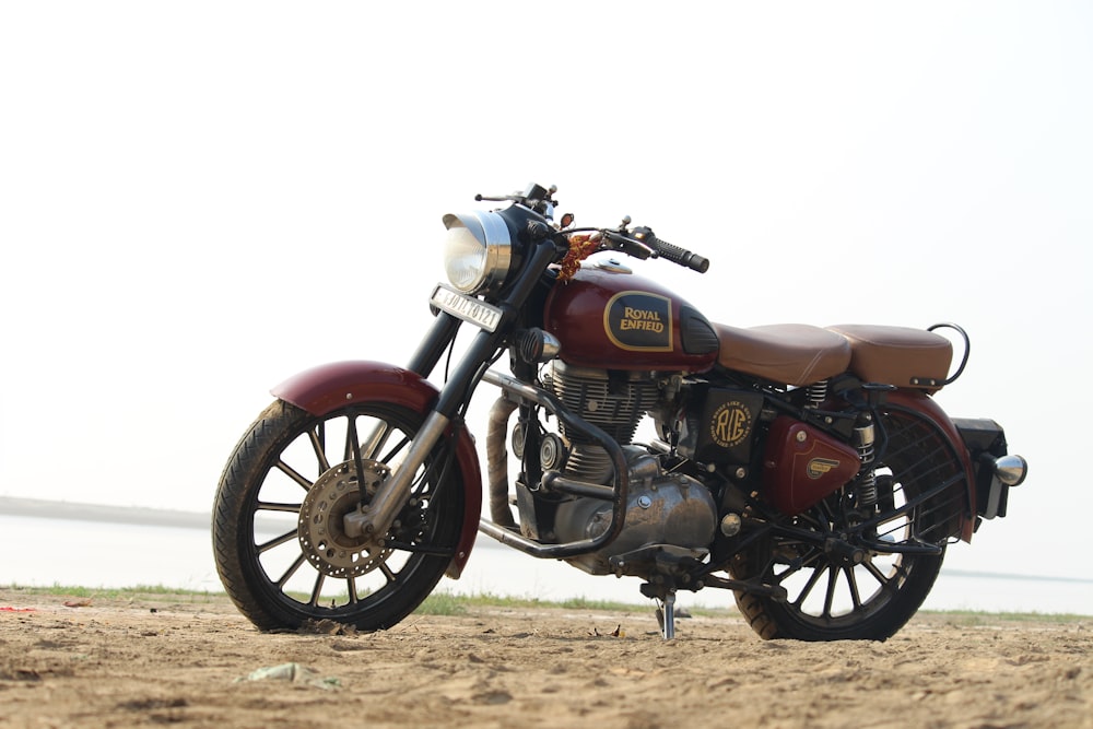 Ein Motorrad, das an einem Strand in der Nähe des Ozeans geparkt ist