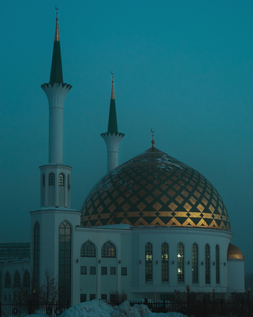 a large white building with two green domes