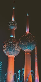 a couple of tall buildings with lights on them