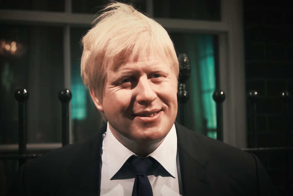 a close up of a person wearing a suit and tie