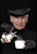 A stylish man in his 30s enjoying a warm cup of herbal drink with a luxurious black and gold background.