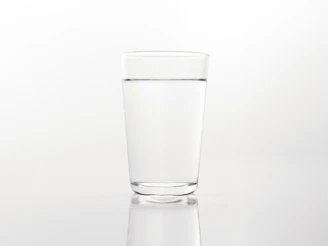 a glass of water on a reflective surface