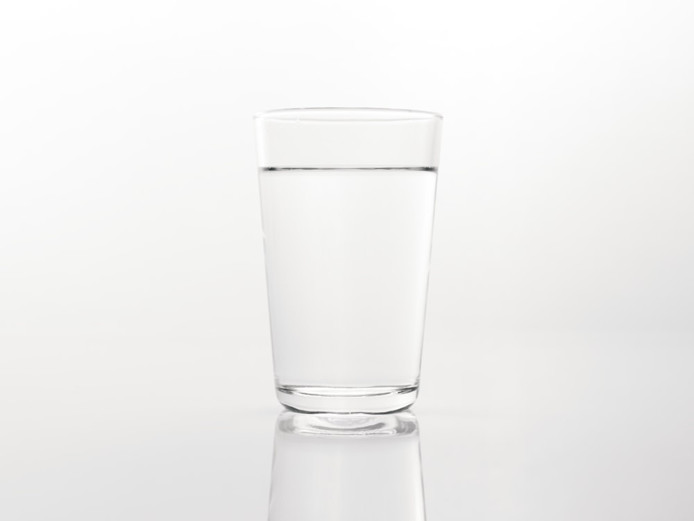 a glass of water on a reflective surface
