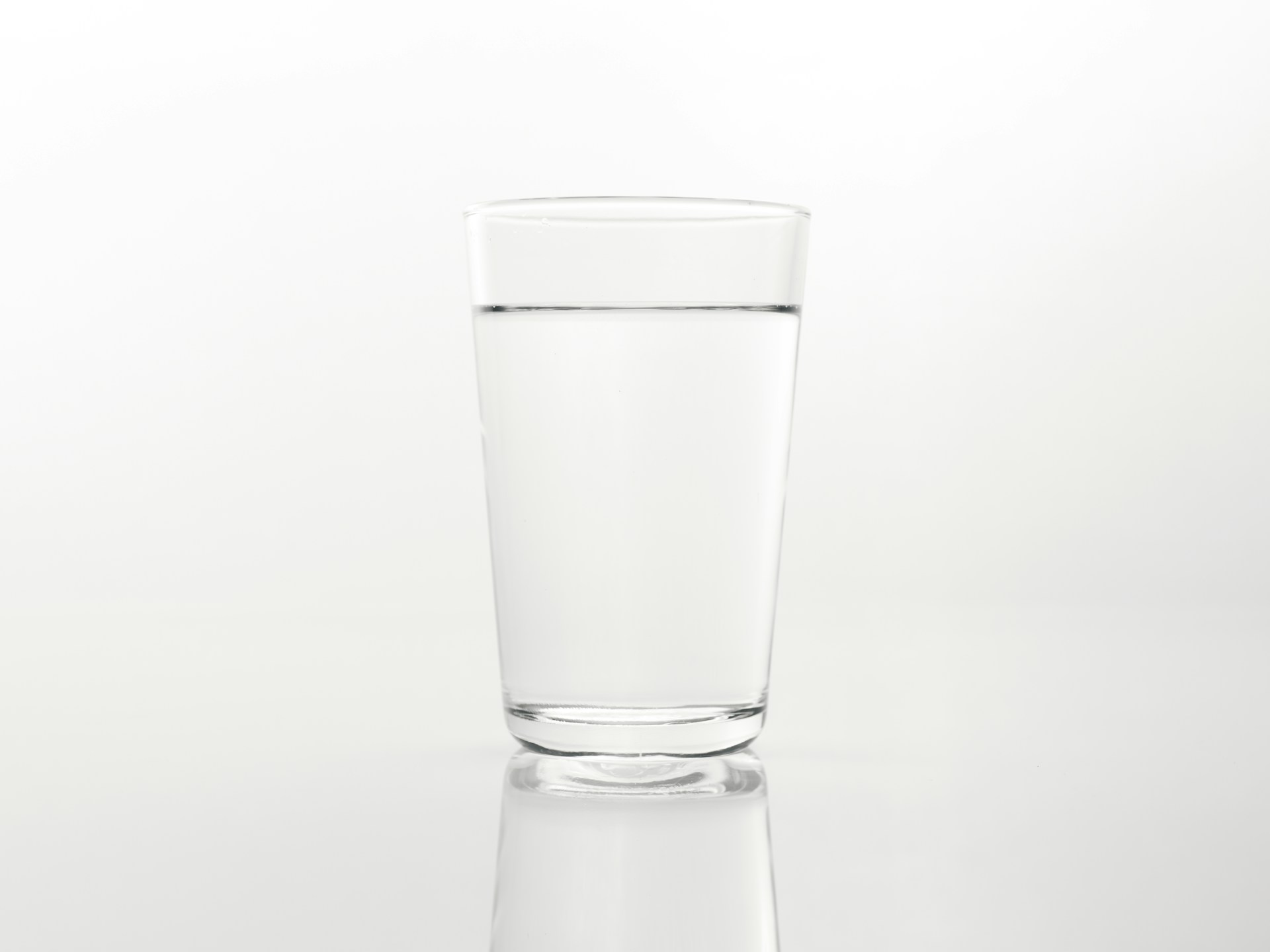 a glass of water on a reflective surface