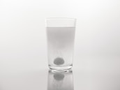 PVA film dissolving in a clear glass of water, illustrating its water-soluble property.