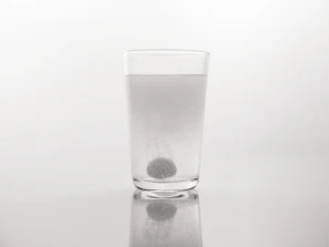 Close-up of a glass of water with a dissolving supplement tablet