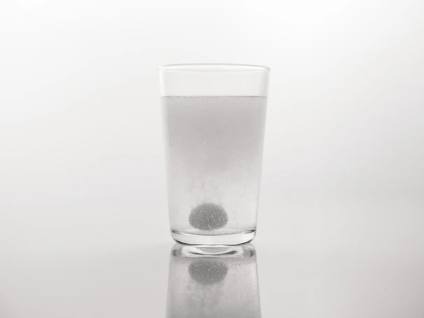 A soft pastel-toned close-up of collagen peptides dissolving in clear water, highlighting purity and clarity.