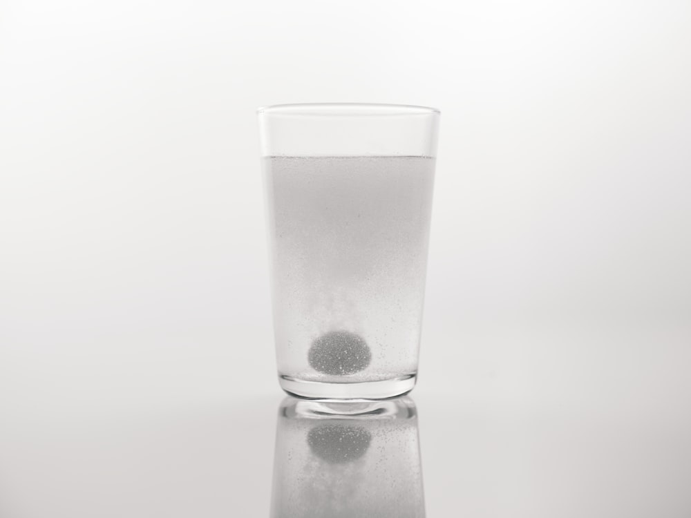 a glass of water with a black dot in it