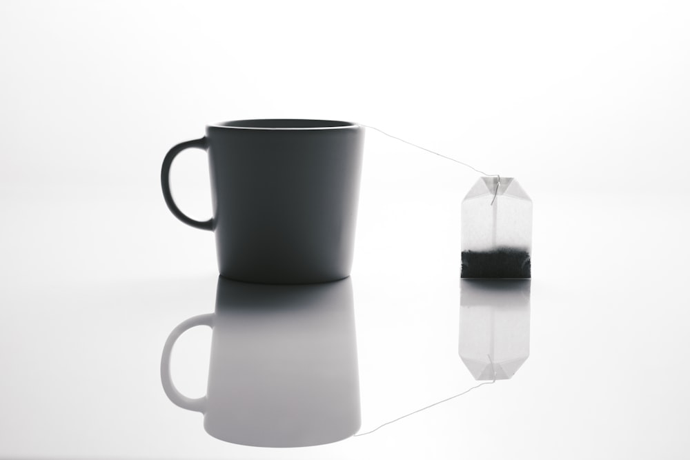 a black coffee cup sitting on top of a table